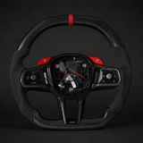 BMW G90 M5 Alcantara steering wheel with red accents on a dark background